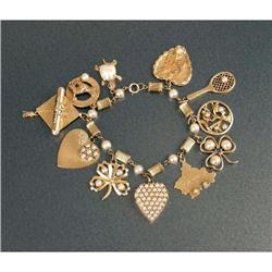 A 14K YELLOW GOLD AND PEARL CHARM BRACELET