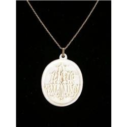 A LARGE ORNATELY-CARVED IVORY OVAL PENDANT