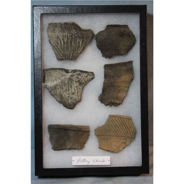 Native American pottery shards and bone tools, framed