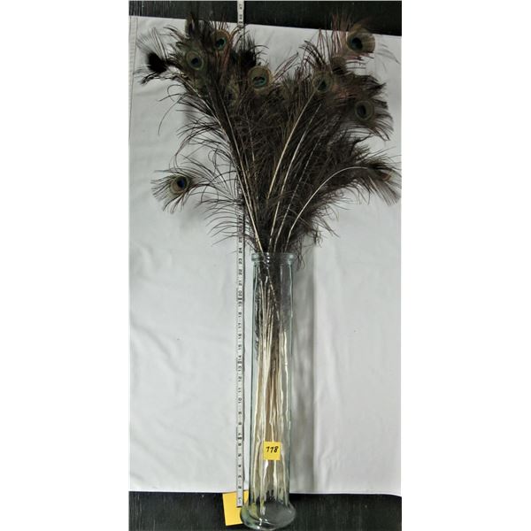 24" clear glass vase and assortment of peacock feathers