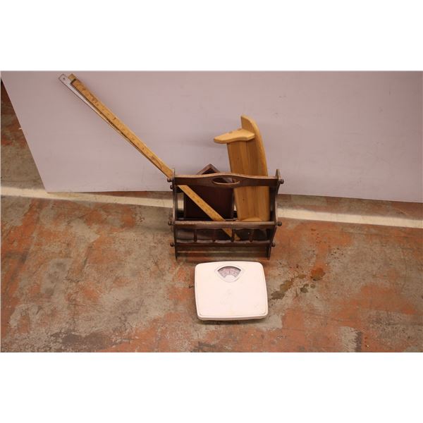 newspaper rack with wooden meter sticks and bathroom scale