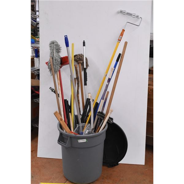 *garbage can + lid, filled with mops, paint roller, brooms, handles, plunger