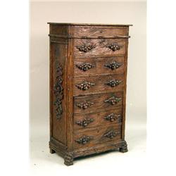 A LARGE ORNATELY CARVED AND STAINED OAK BLACK FOREST-STYLE CHEST OF DRAWERS