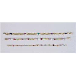 AN 18K YELLOW GOLD, RUBY, SAPPHIRE AND EMERALD LINK BRACELET