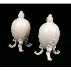 A PAIR OF GERMAN PORCELAIN FOOTED COVERED EGG-FORM URNS