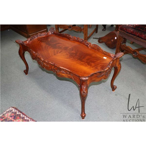 Semi contemporary flame mahogany baroque style coffee table with carved floral accents