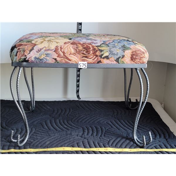 Cushioned metal footstool with rebar legs.