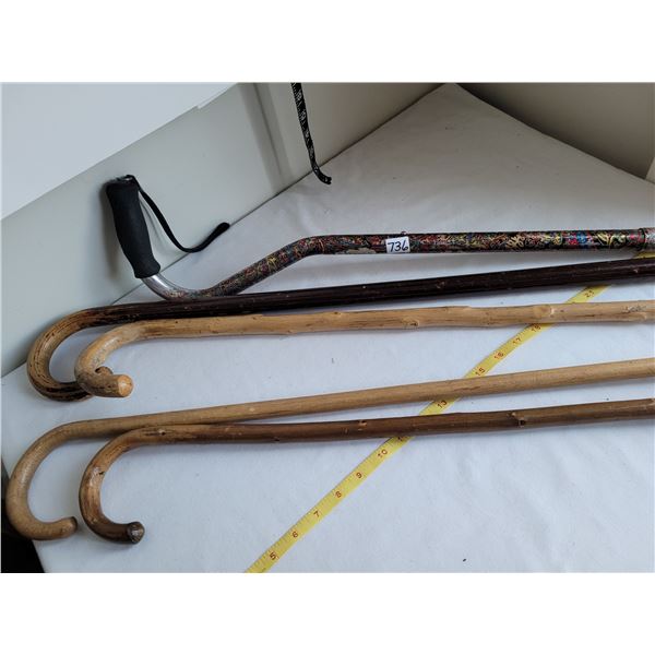 4 old wood canes & 1 adjustable metal cane.