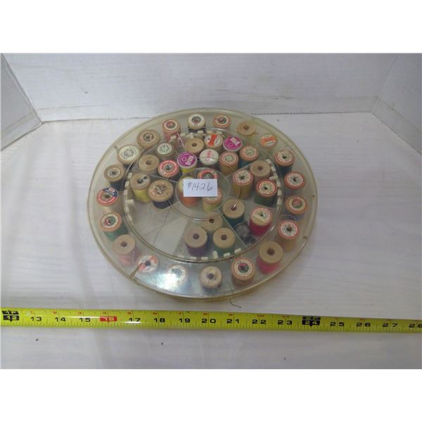 Container of vintage wooden spools with thread