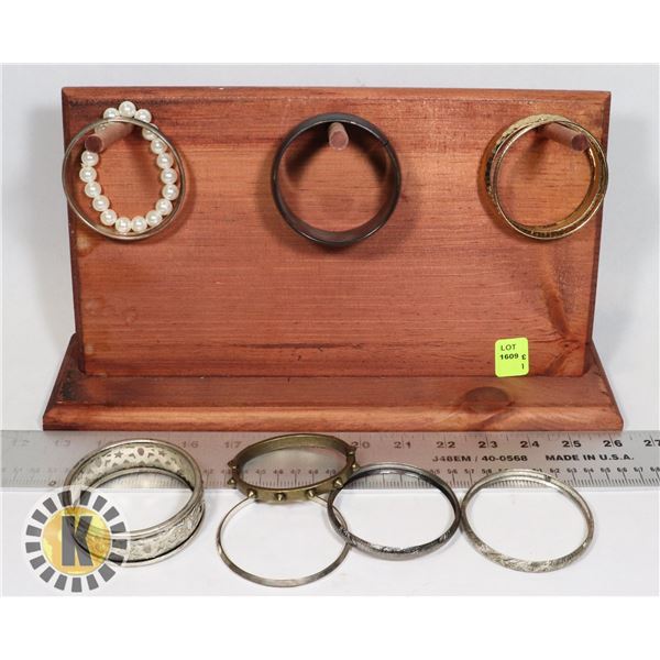 COLLECTION OF BRACELETS ON WOOD JEWELRY STAND