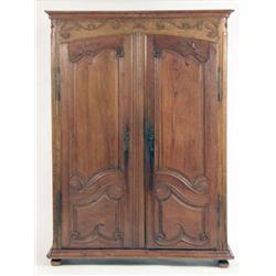 A PROVINCIAL CARVED OAK ARMOIRE
