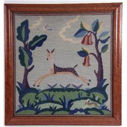 A FRAMED NEEDLEWORK OF A DEER IN A LANDSCAPE