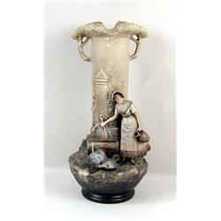 A POLYCHROME-DECORATED DOUBLE-HANDLED FIGURAL PORCELAIN VASE
