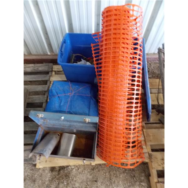 Pallet with orange fence, tarp, tote, bench tool box