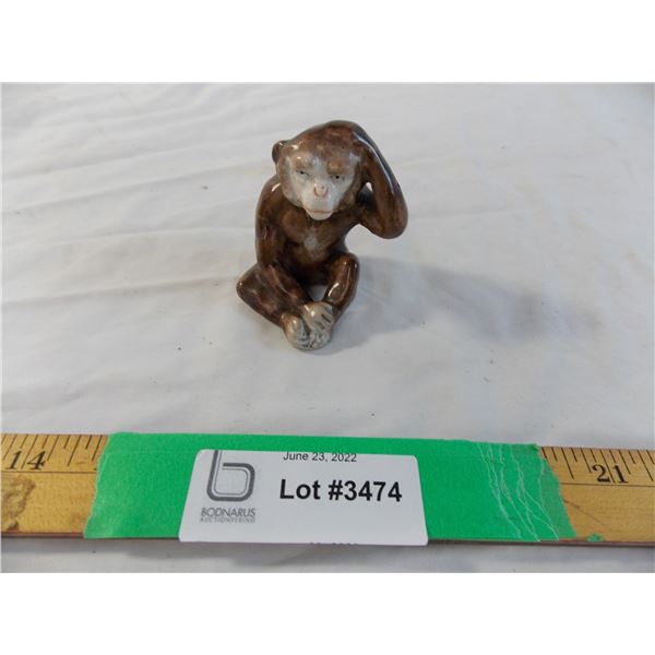 Ceramic monkey scratching his head figure