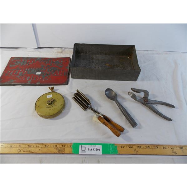 Vintage curling iron tool and ice cream scoop in biscuit tin