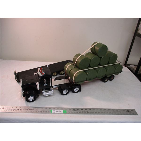 Peterbilt semi with custom built flat trailer and round bales