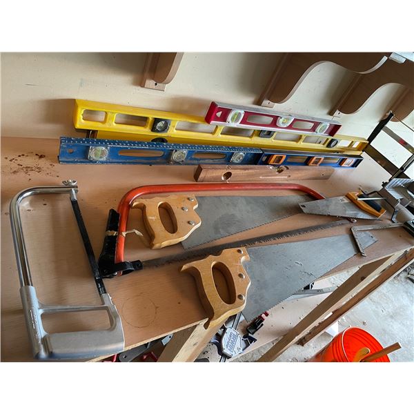 Bulk lot of hand saws and levels.
