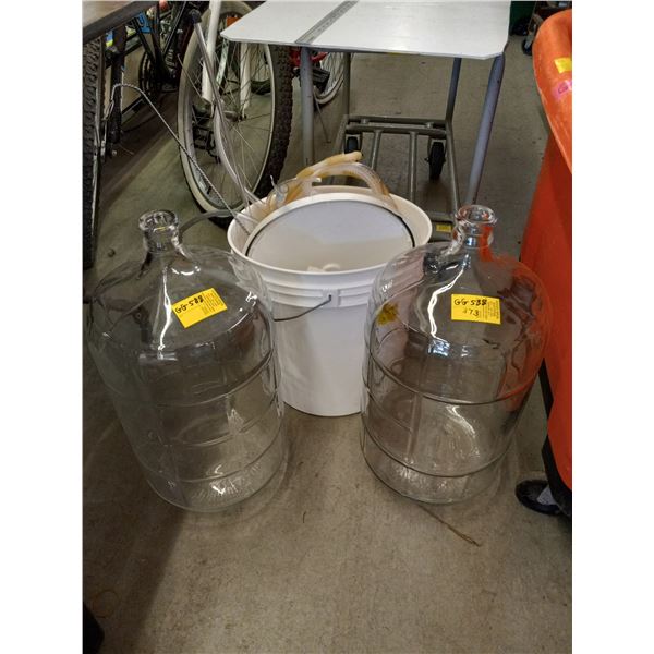 TWO GLASS CARBOYS AND BUCKET WITH WINE MAKING ITEMS