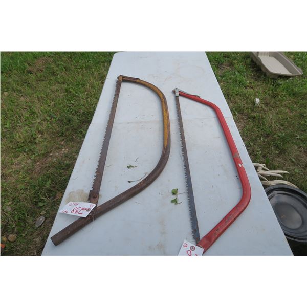 2 -  large hand buck saws, 1 red , 1 rusty yellow
