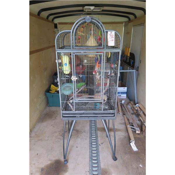 large grey bird cage with stand and misc items.