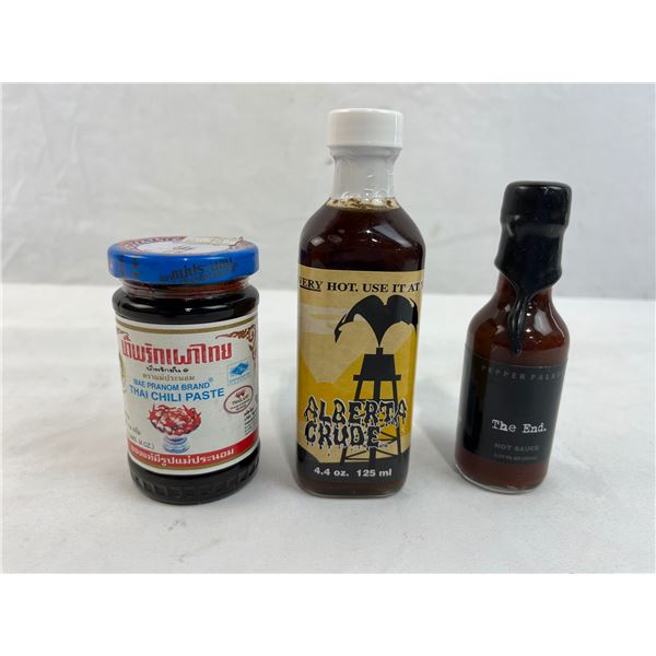 Three unopened bottles of hot sauce