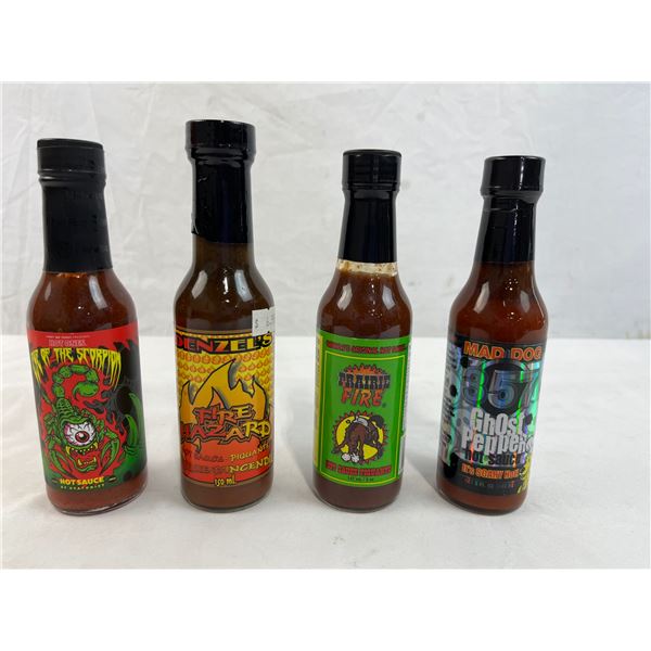 Four mixed unopened bottles of hot sauce
