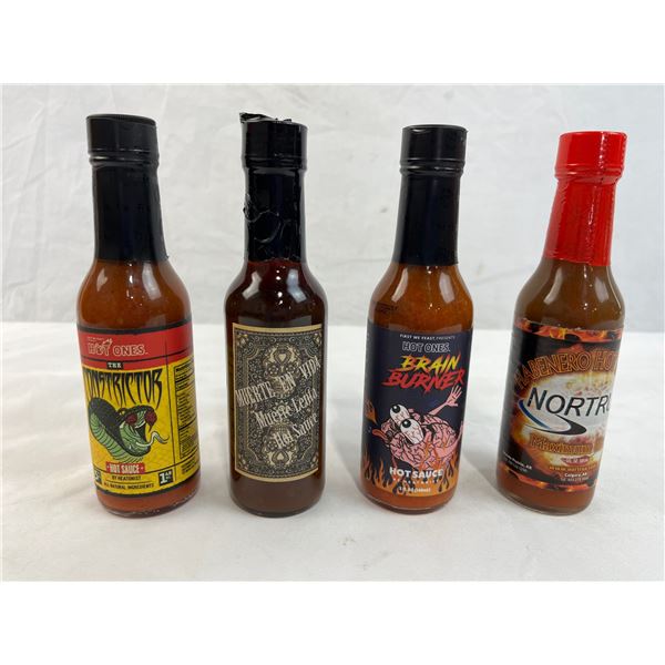 Four mixed unopened bottles of hot sauce