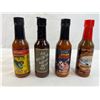 Four mixed unopened bottles of hot sauce