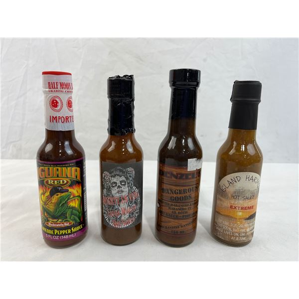 Four mixed unopened bottles of hot sauce