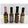 Four mixed unopened bottles of hot sauce