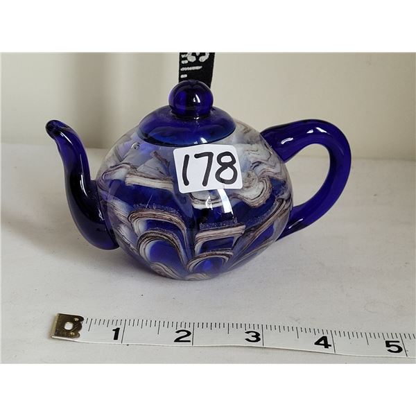 Glass teapot paper weight.