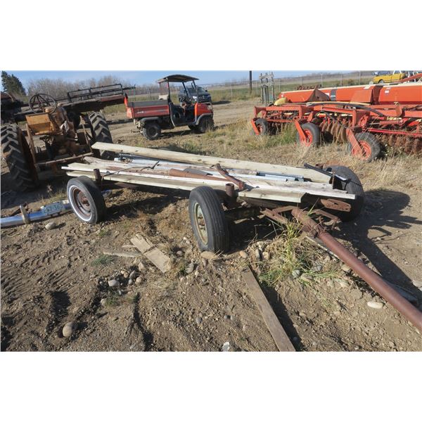 Double axle hay trailer with misc wood items on it