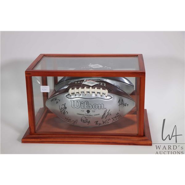 Team signed CFL Edmonton Eskimos football in display case