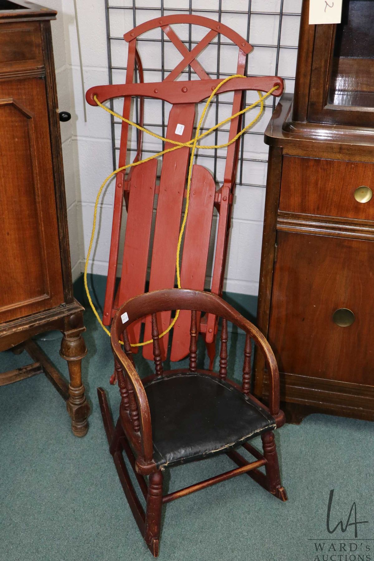 Child's antique rocker with leather seat and a small wooden sled with ...