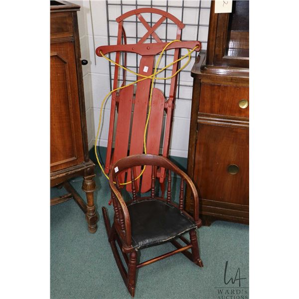 Child's antique rocker with leather seat and a small wooden sled with metal runners