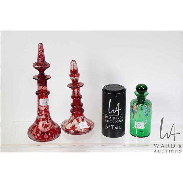 Three antique perfume bottles including hand painted green Bohemian glass and two red cut to clear b