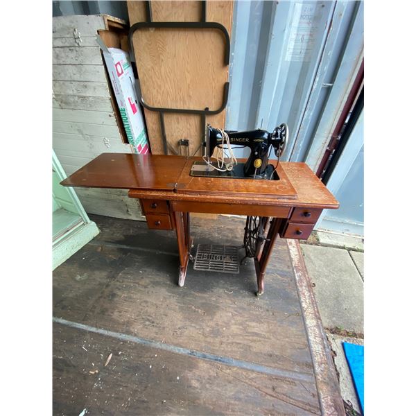 Singer Treadle sewing machine with electric light (water damaged to bottom of table) on casters