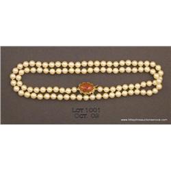 28 inch strand of 6.5 to 7mm pearls with 14kt  yellow gold oval orange jade clasp.  Est. $400 -  $80