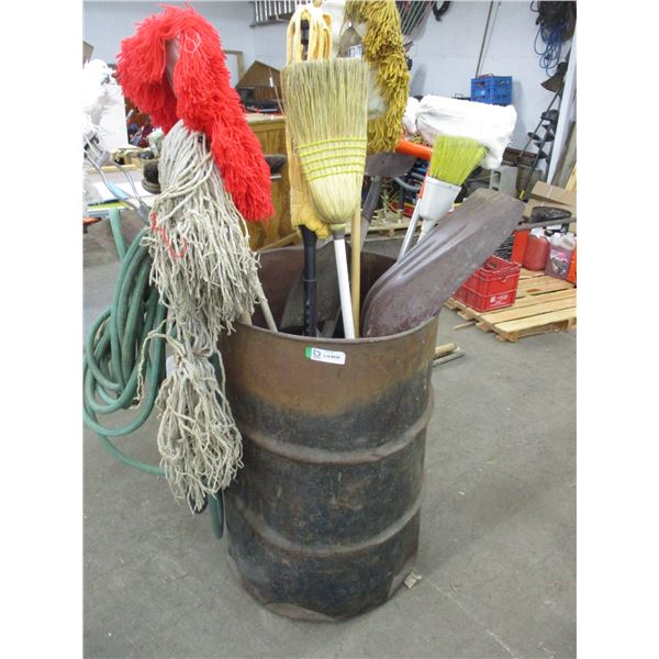 Metal barrel with garden tools, hose