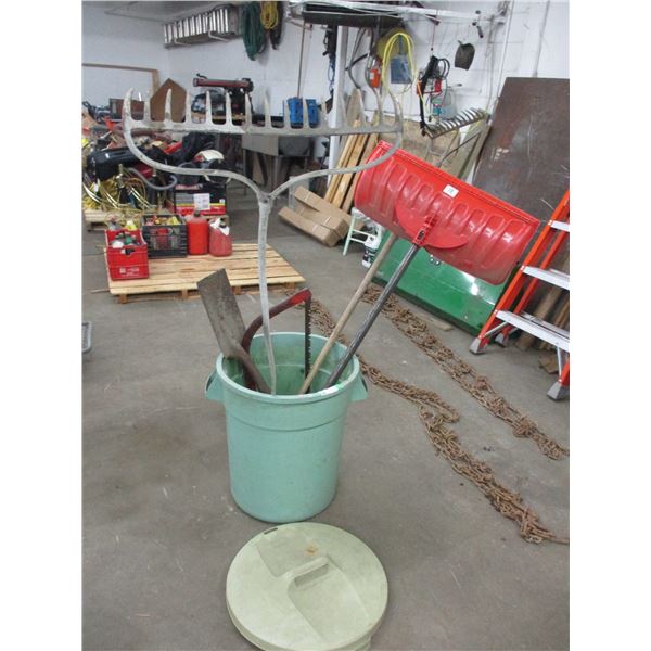 Garbage can with 2 rakes, bucksaw, shovels