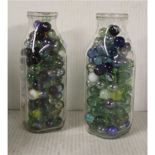 TWO MILK BOTTLES WITH MARBLES