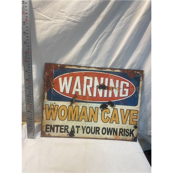 Woman cave tin sign