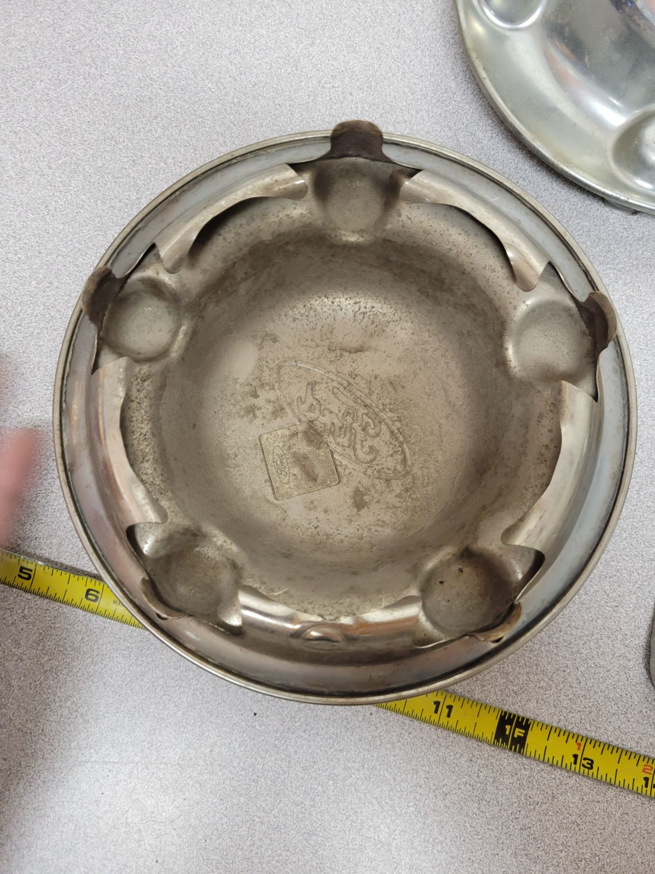 Three Ford wheel center caps / license plate frame Schmalz Auctions