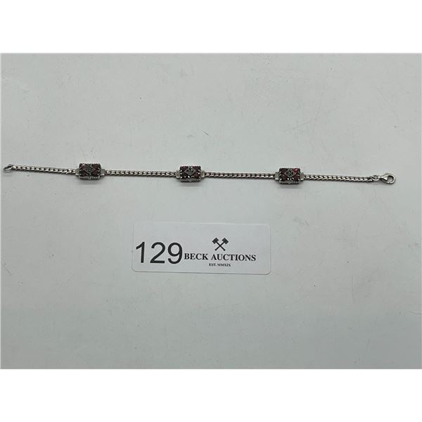 Silver bracelet with red gemstones
