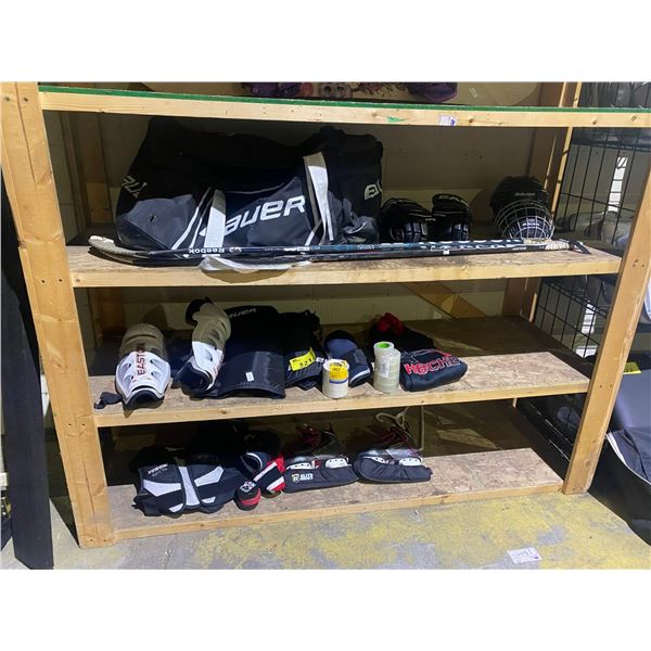 3 SHELVES OF HOCKEY GEAR; PADS, SKATES, STICKS, HELMET AND MORE