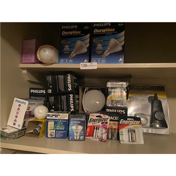 Closet shelf full of light bulbs of different watts and batteries