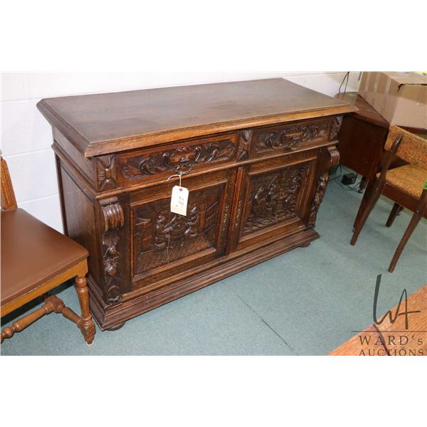 Antique quarter cut oak sideboard with carved scenes in raised panel doors and other decorative carv