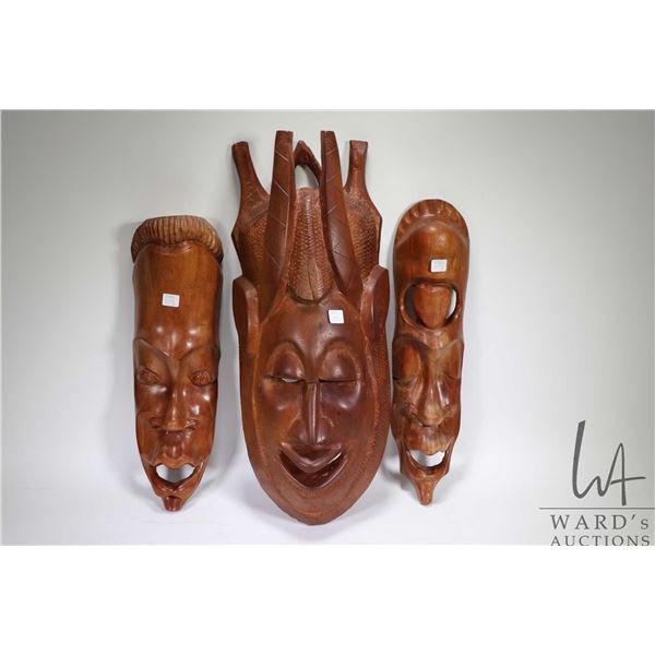 Three heavy carved wooden masks ranging from 18 1/2" X 24"