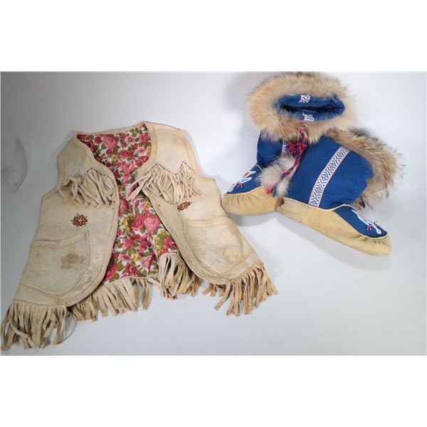 Pair of beaded and fur lined moccasins and a beaded and tasseled leather vest, no size mark but quit